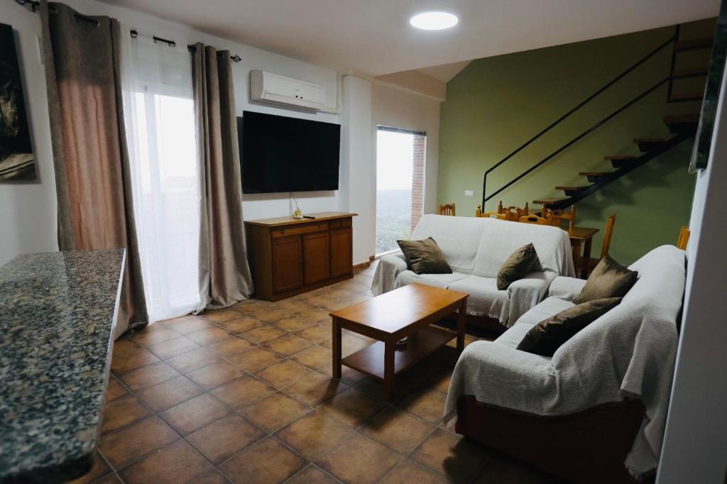 a living room with two couches and a tv at Alojamiento Sierra Cazorla in La Iruela