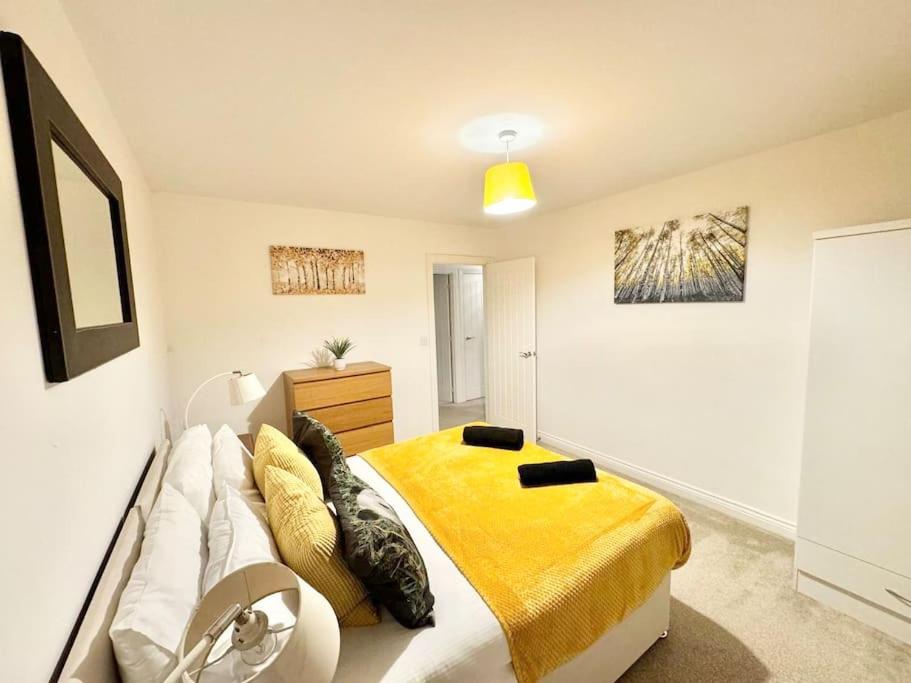 a bedroom with a bed with a yellow blanket at Stay for business, corporate, contractors or leisure with private parking in Ashford