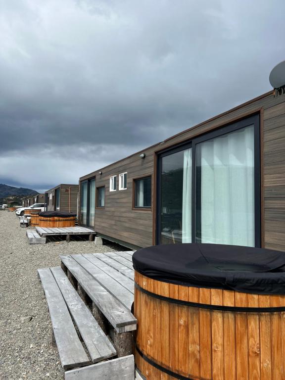 a row of tiny houses with a wooden barrel at Chelenko Lodge in Puerto Tranquilo