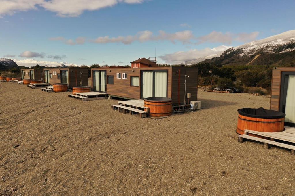 a row of tiny houses sitting in a field at Chelenko Lodge in Puerto Tranquilo