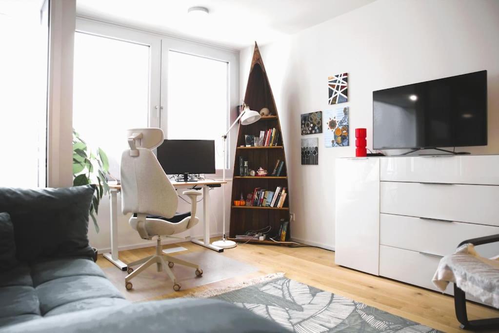 a living room with a couch and a desk with a computer at Cozy Stylish Studio near Luxembourg City Centre in Luxembourg