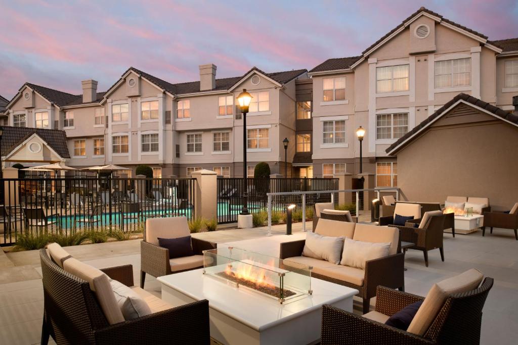 a patio with chairs and tables and a building at Residence Inn Pleasanton in Pleasanton