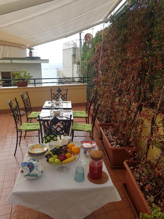 a table with a plate of fruit on a patio at B&B DieMme Amalfi Coast in Vietri sul Mare