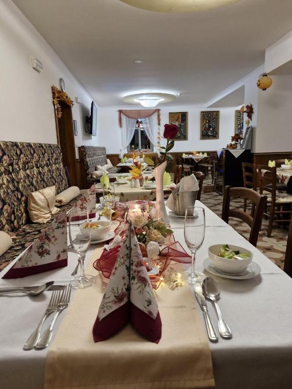 długi stół z białą ścierką stołową i kieliszkami do wina w obiekcie Parkhotel Forest w Mariańskich Łaźniach