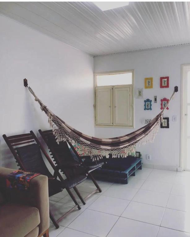 a hammock in a living room with a couch at Temporada Rei do Cangaço in Piranhas
