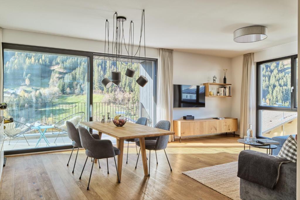 a living room with a wooden table and chairs at Stilvolles, lichtdurchflutetes Luxus-Appartement in der Residenz Silvretta - Inklusive Silvretta Card Premium in See