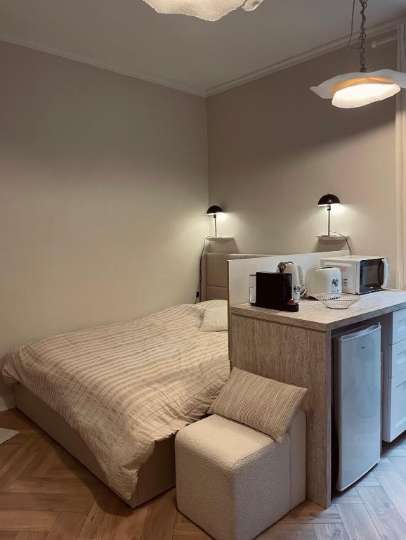 - une chambre avec un lit, un four micro-ondes et une chaise dans l'établissement Le cocon de Rouen, à Rouen