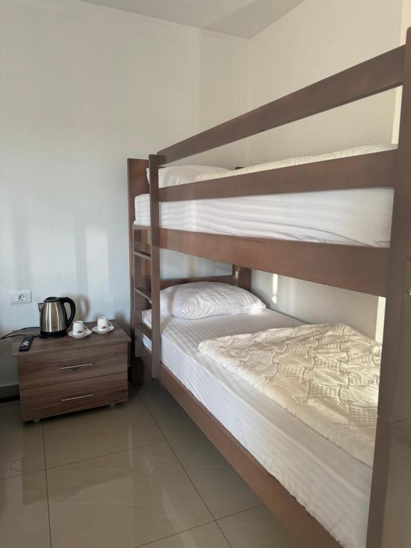 two bunk beds in a room with a night stand at Hotel Palace Struga in Struga