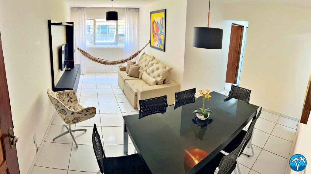 a living room with a table and a couch at Vacanze - Jardim Tropical in Maceió