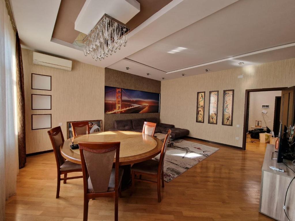uma sala de jantar com mesa e sofá em Gamma em Baku