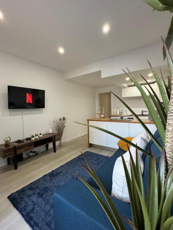 a living room with a blue couch and a tv at Apartamento em Cascais in Cascais
