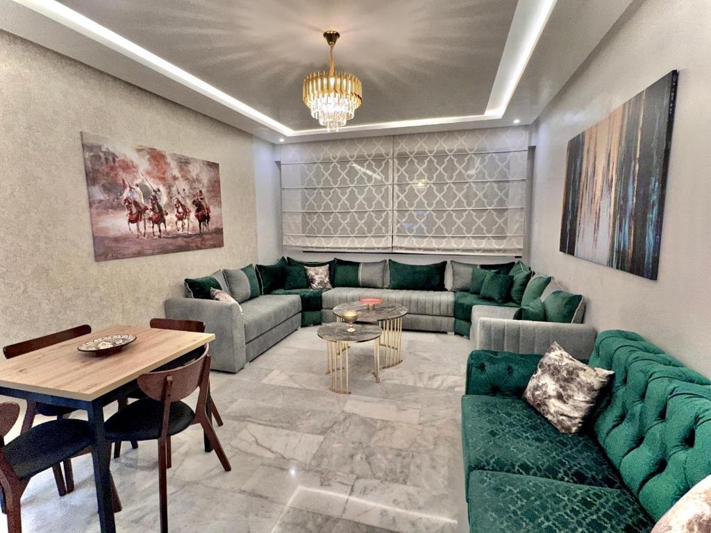 un salon avec des canapés verts et une table dans l'établissement Liliapart, à Agadir