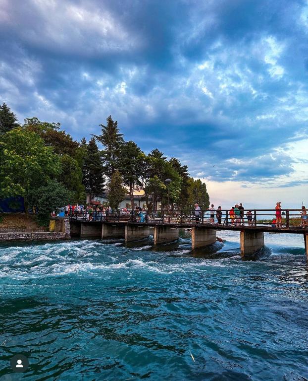 a group of people crossing a bridge over a river at Hotel Palace Struga in Struga