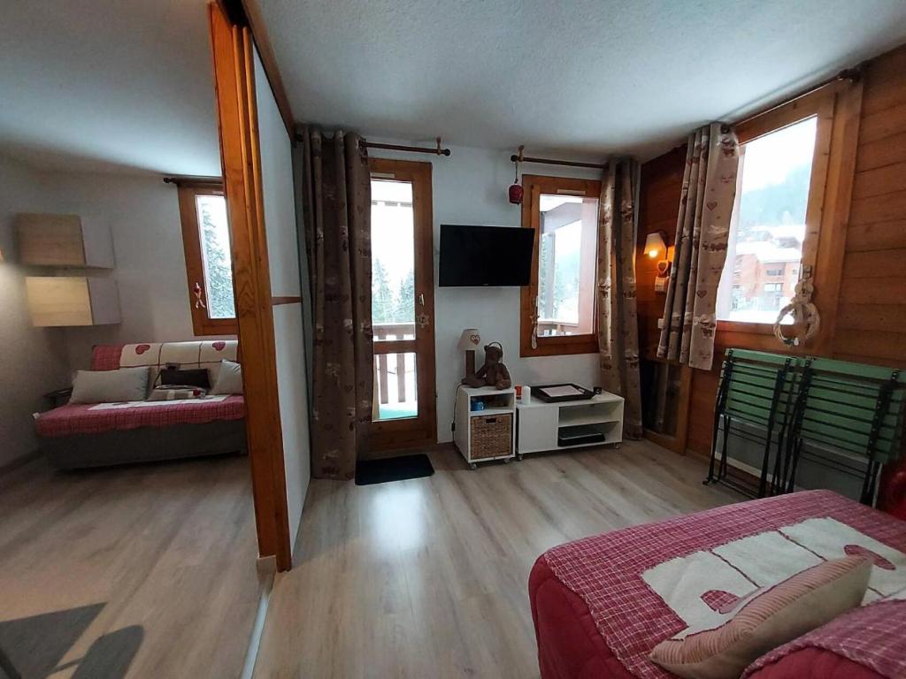 Cet appartement comprend une chambre avec un lit et un salon avec des fenêtres. dans l'établissement Résidence Lauziere Dessous G - La Lauziere Dessous 6 MAE-2201, à Valmorel