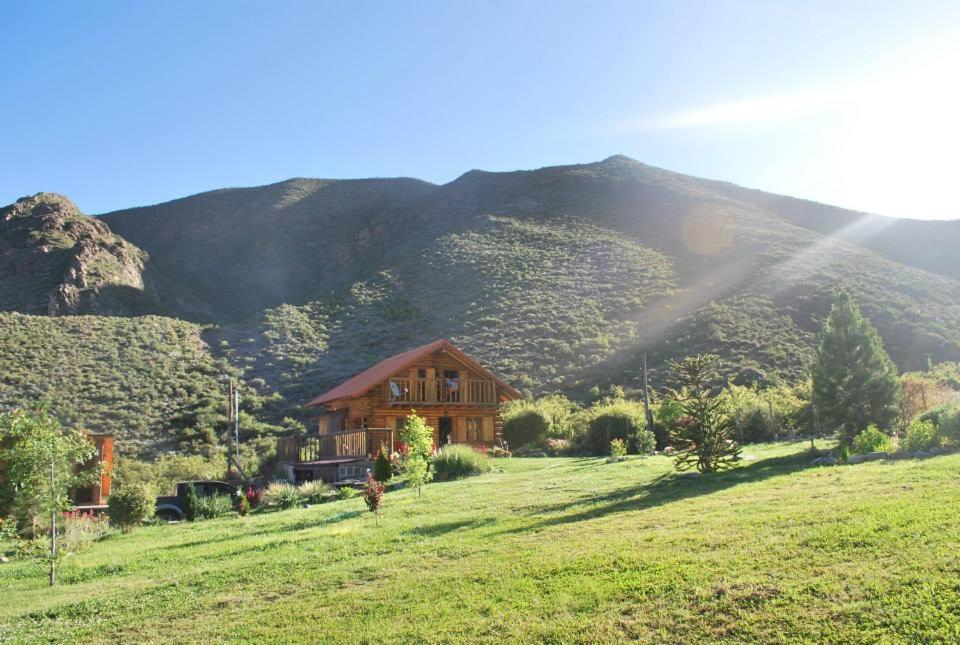 a house in a field with a mountain in the background at La Araucaria in Potrerillos