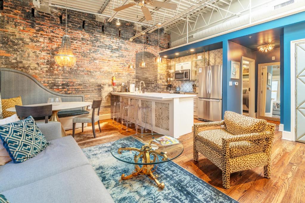 a living room with a couch and chairs and a kitchen at 80 Lex 203 Eclectic Industrial Apt in Asheville
