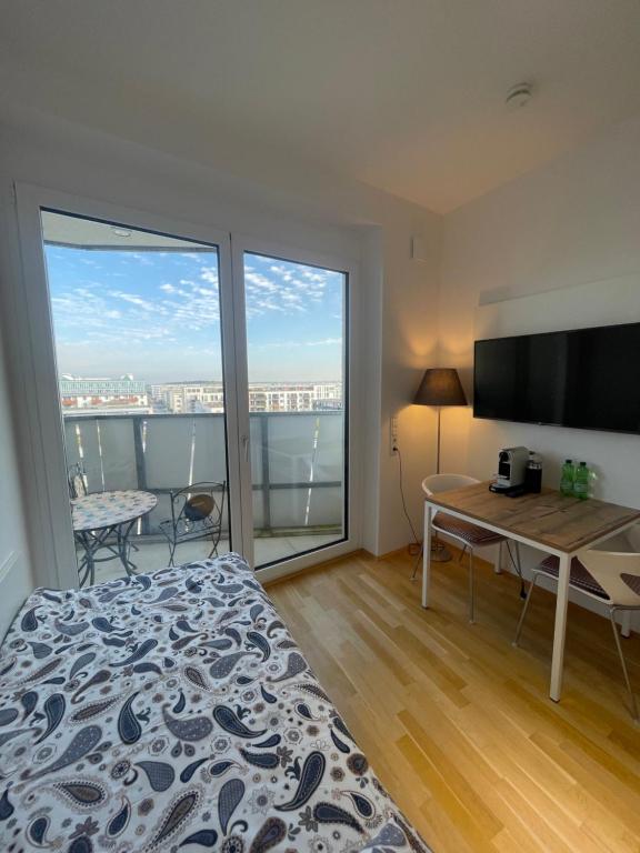 ミュンヘンにあるMy Room at Munich Fairのベッドルーム1室(ベッド1台、大きな窓のあるデスク付)