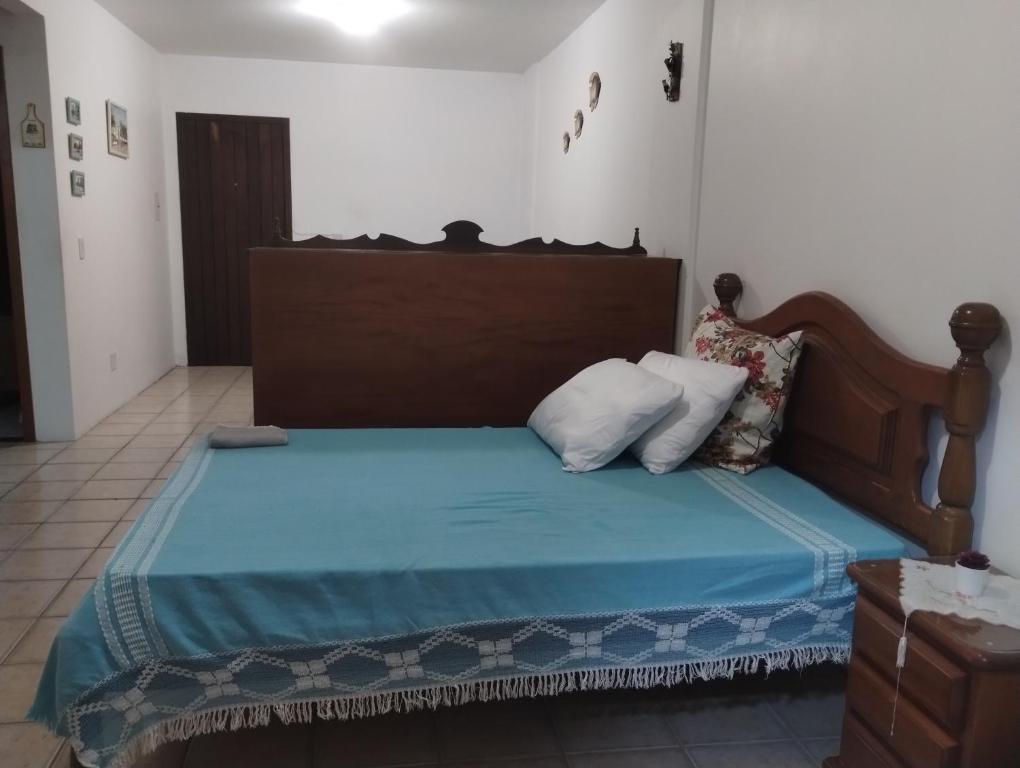 a bedroom with a bed with a wooden headboard at Torres a mais bela praia gaúcha in Torres