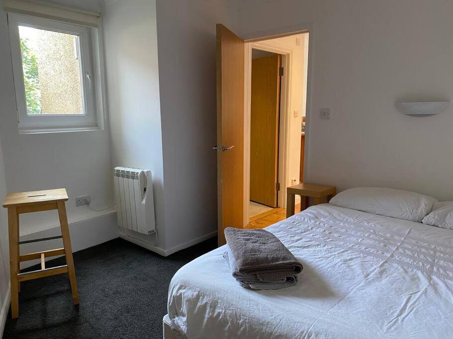 a bedroom with a bed with a towel on it at Lovely centrally located 2 bed flat in Southsea in Portsmouth