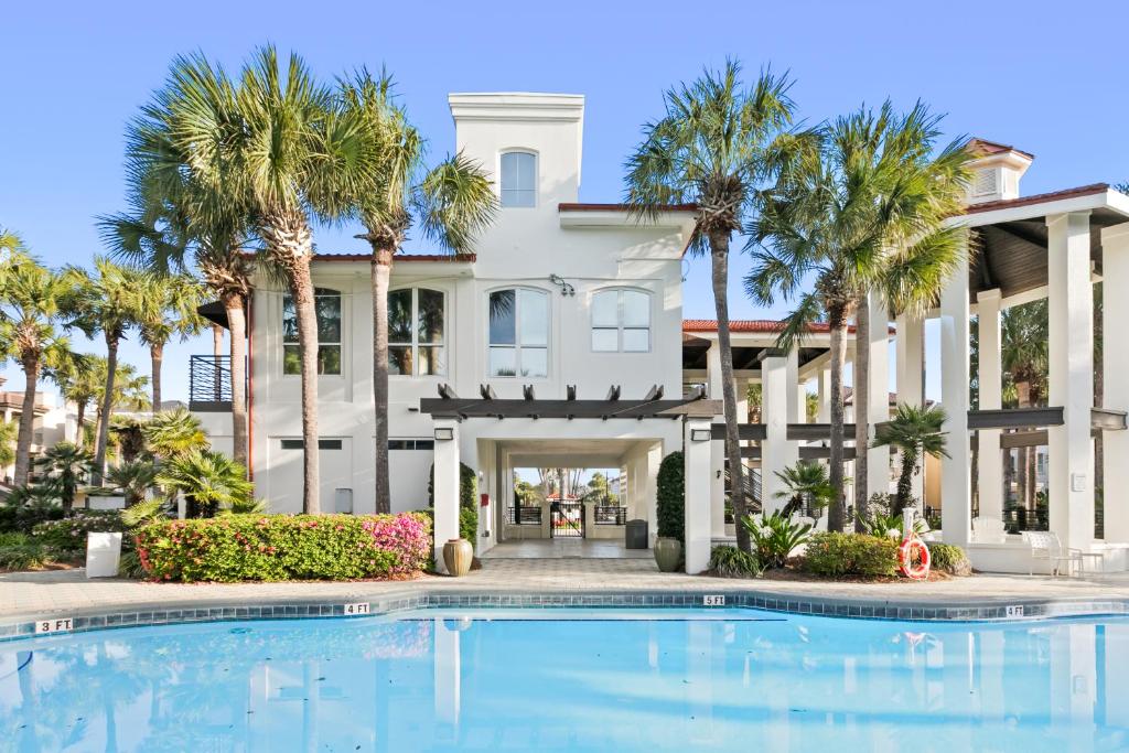 デスティンにあるLuxury Community Pool, Hot Tub and Beach and Gamesのヤシの木とスイミングプールのある大きな白い家