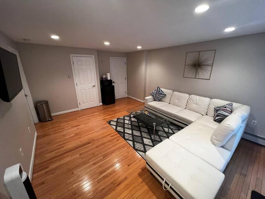 ein Wohnzimmer mit weißem Sofa und Holzboden in der Unterkunft Premium Private Suite with Parking and Workspace in South Windsor
