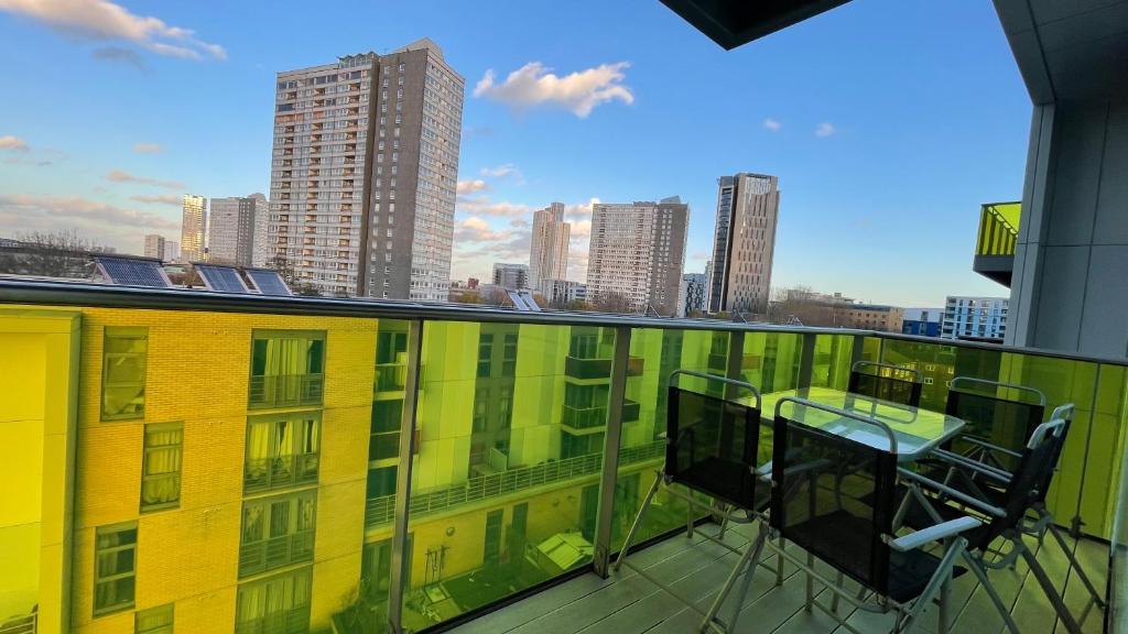 a balcony with a table and chairs on a building at Stratford 2 bedroom Apartment with 2 Bathrooms & Great Links in London