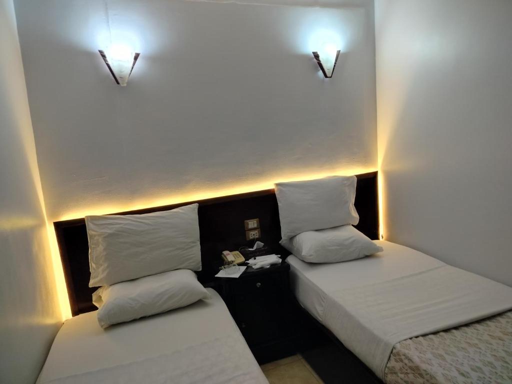 Postel nebo postele na pokoji v ubytování Abo Elwafa Hotel