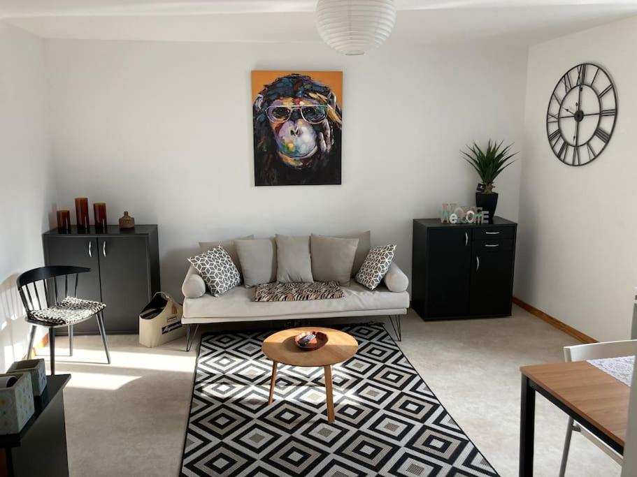 a living room with a couch and a painting of a dog at Duplex proche du centre-ville in Decize