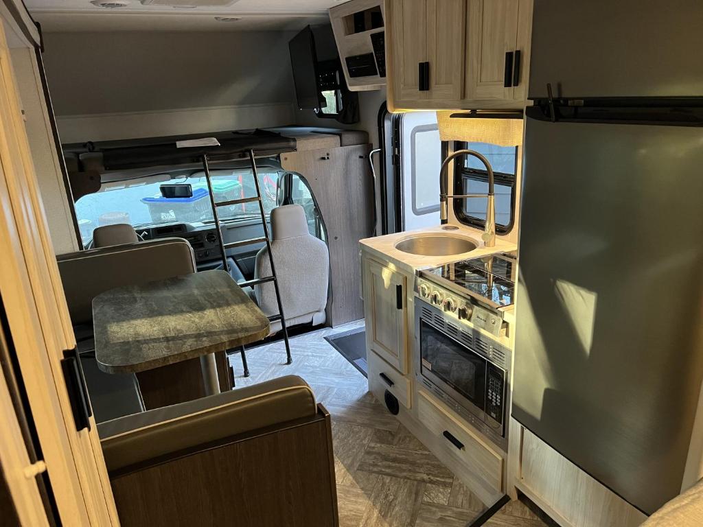 an rv kitchen with a sink and a refrigerator at RV In Orlando No Local Guests in Orlando