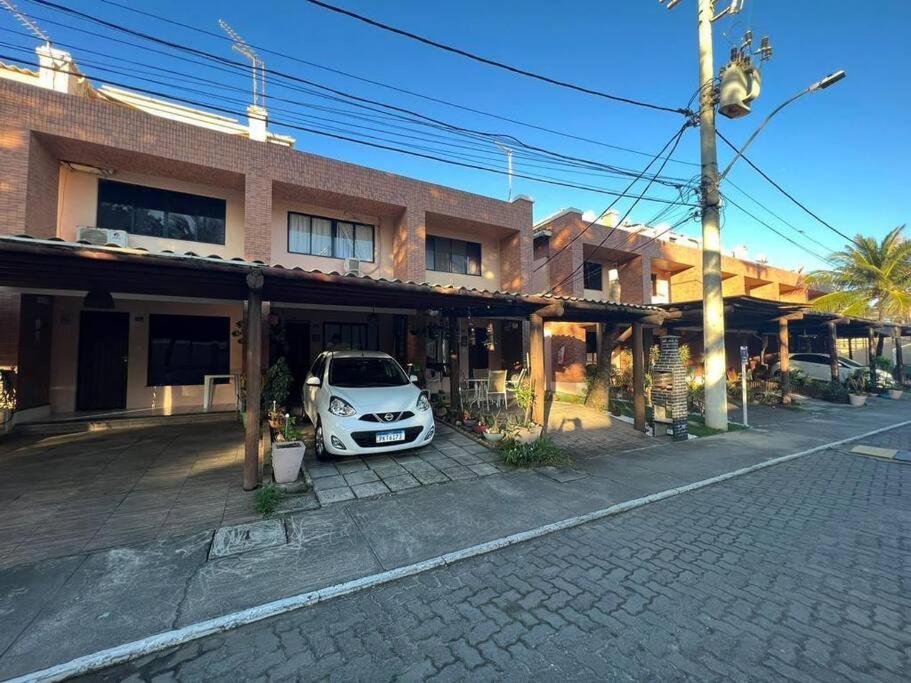 a white car parked in front of a building at Casa aconchegante perto da praia in Salvador