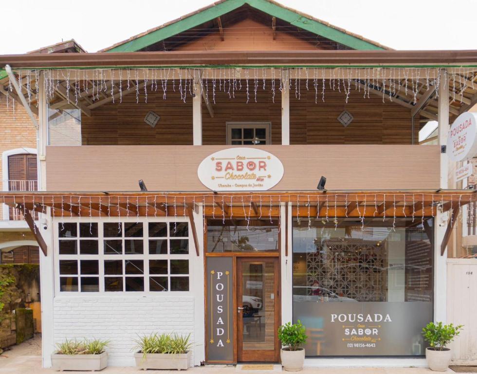 Un escaparate con un cartel de peluquería en Casa Sabor Chocolate Mar, en Ubatuba