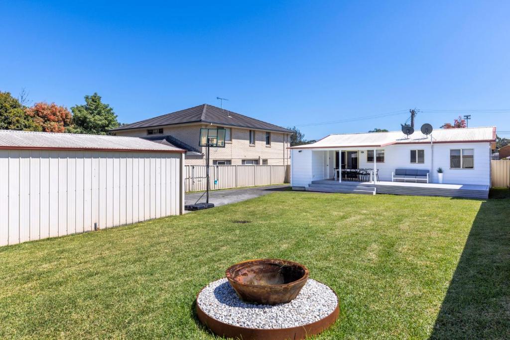 a yard with a pot in the grass at High Tide - Pet Friendly with Fire Pit in Sanctuary Point