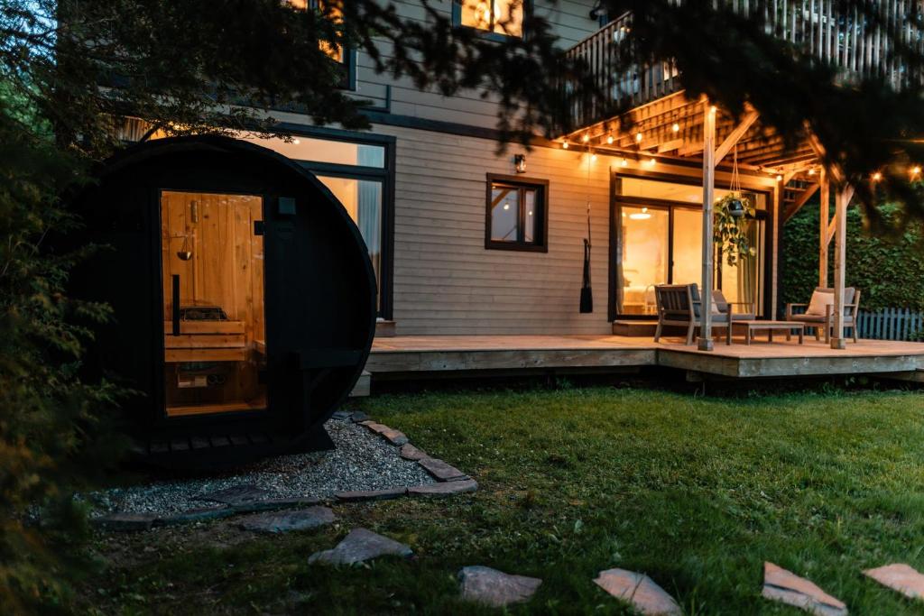 Chalet Chti - bord de l'eau mont Orford في ايستمان: منزل فيه باب خشبي وفناء