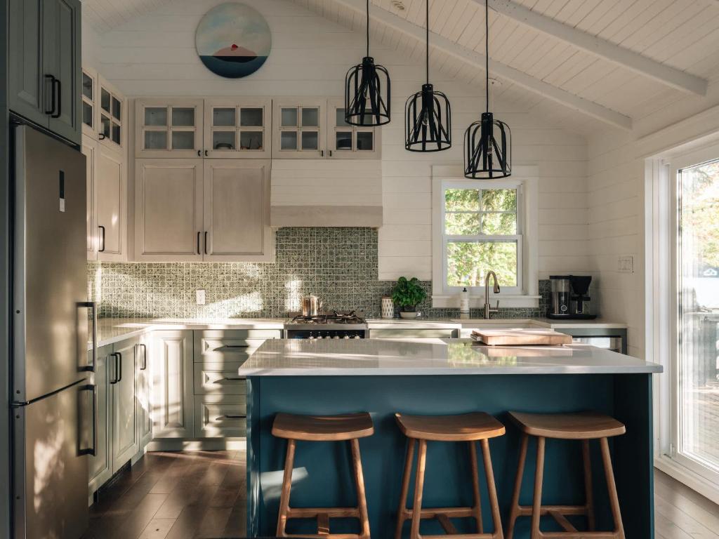 a kitchen with a blue island with bar stools at The Owl's Nest - Lakeside peacefulness ski & hiking in Austin