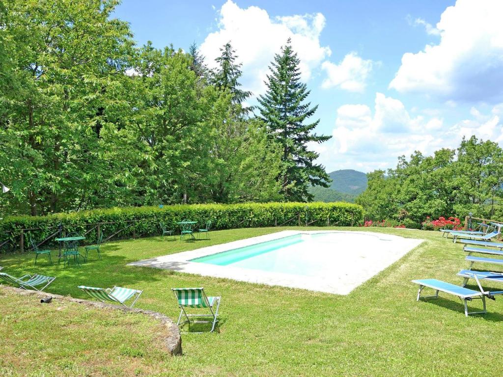 a swimming pool with lawn chairs and a group at Belvilla by OYO Villa Roseto in Poggioni