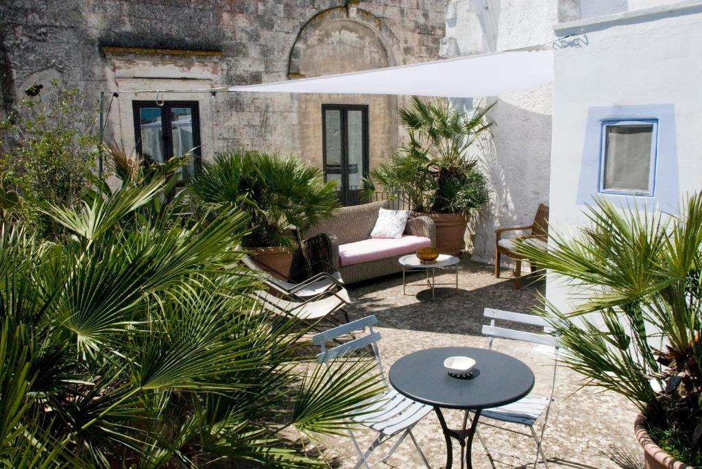 eine Terrasse mit einem Sofa, Stühlen und Pflanzen in der Unterkunft Dimora Santi-Mancuso by BarbarHouse in Presicce