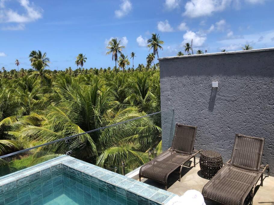 a resort with two chairs and a swimming pool at Recanto dos Coqueirais in São Miguel dos Milagres