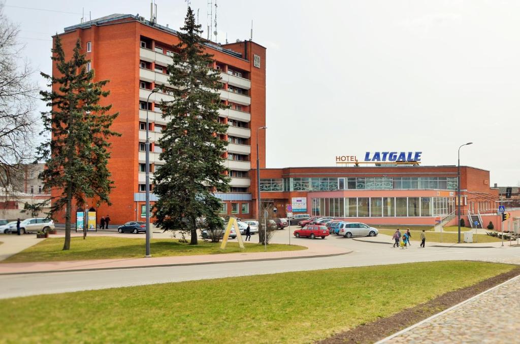ein großes rotes Backsteingebäude mit einem Parkplatz in der Unterkunft Latgale in Rēzekne
