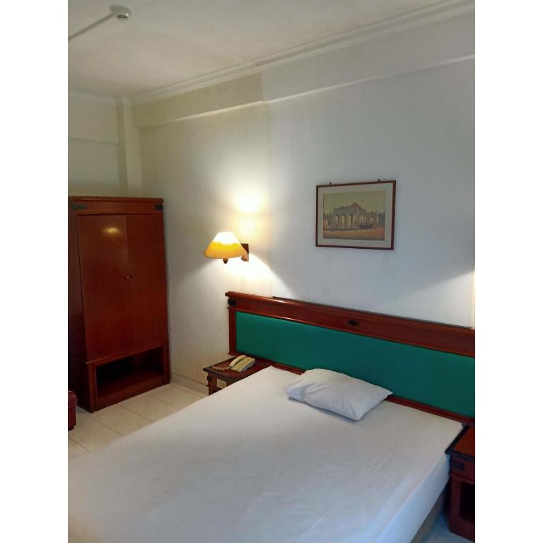 Postel nebo postele na pokoji v ubytování Puri Jaya Hotel