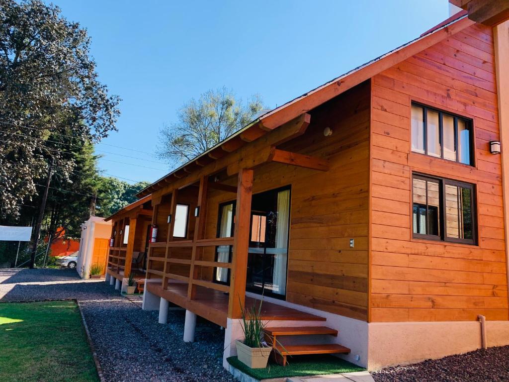 Cette cabane en rondins comprend une terrasse couverte et des escaliers. dans l'établissement Cabaña cerca de la naturaleza, a 20min de Valle, à Valle de Bravo