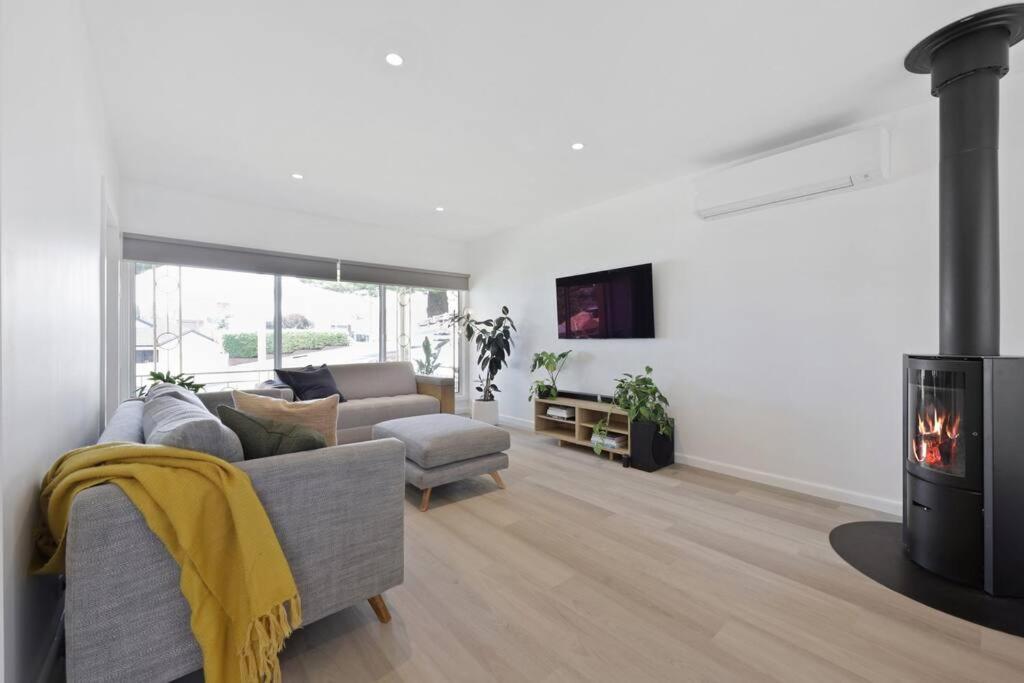 a living room with a couch and a fireplace at 3 bedroom, pet friendly home CBD in Warrnambool