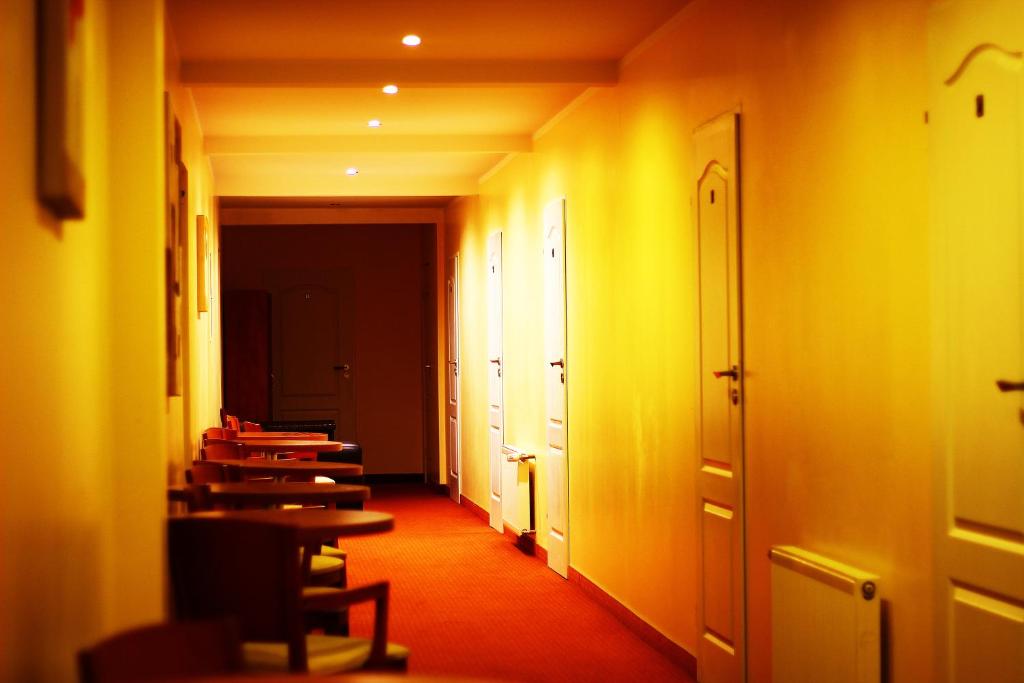pusty korytarz z biurkami w pokoju z żółtymi ścianami w obiekcie Kardamon w mieście Żary