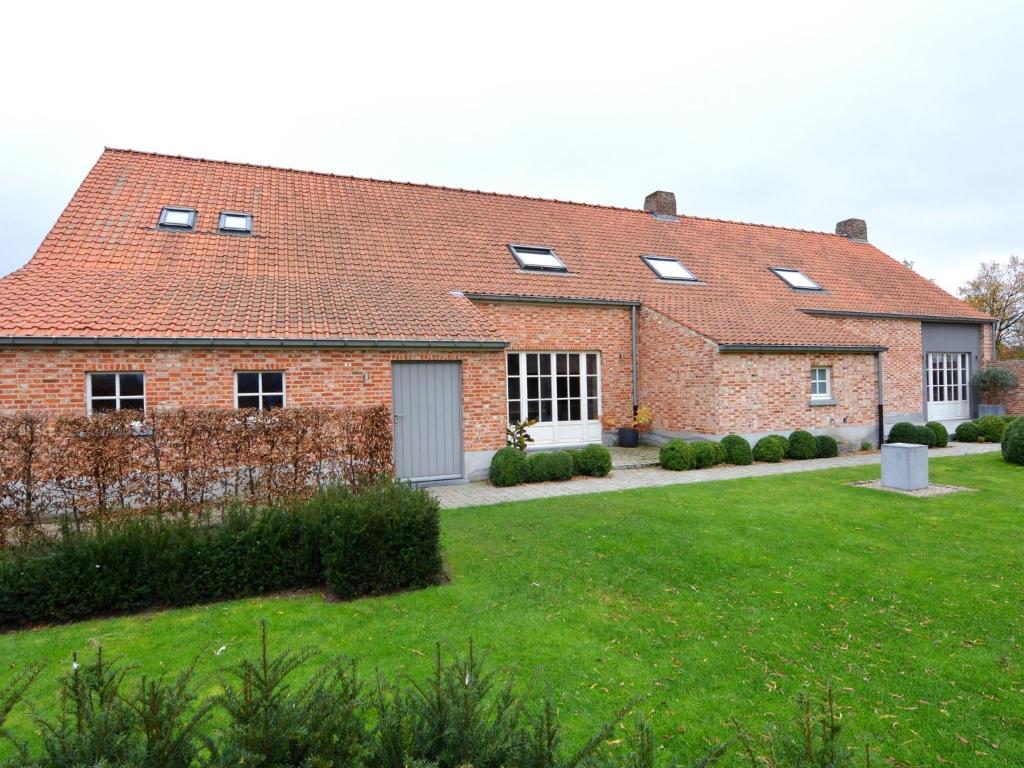 une grande maison en briques avec une cour d'herbe dans l'établissement Modern Home in Geel with Sauna, à Nederheide