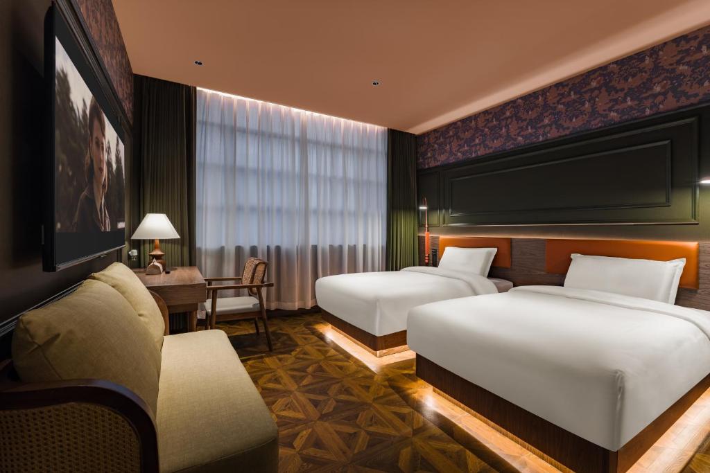 een hotelkamer met twee bedden en een bureau bij 超时光酒店 广州天河岗顶地铁站店 in Guangzhou