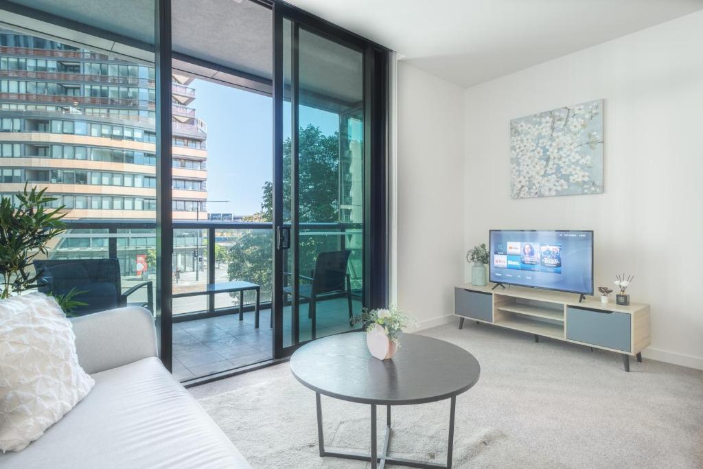 a living room with a tv and a table at Immaculate 1br Apt In Docklands Pool Free Parking in Melbourne