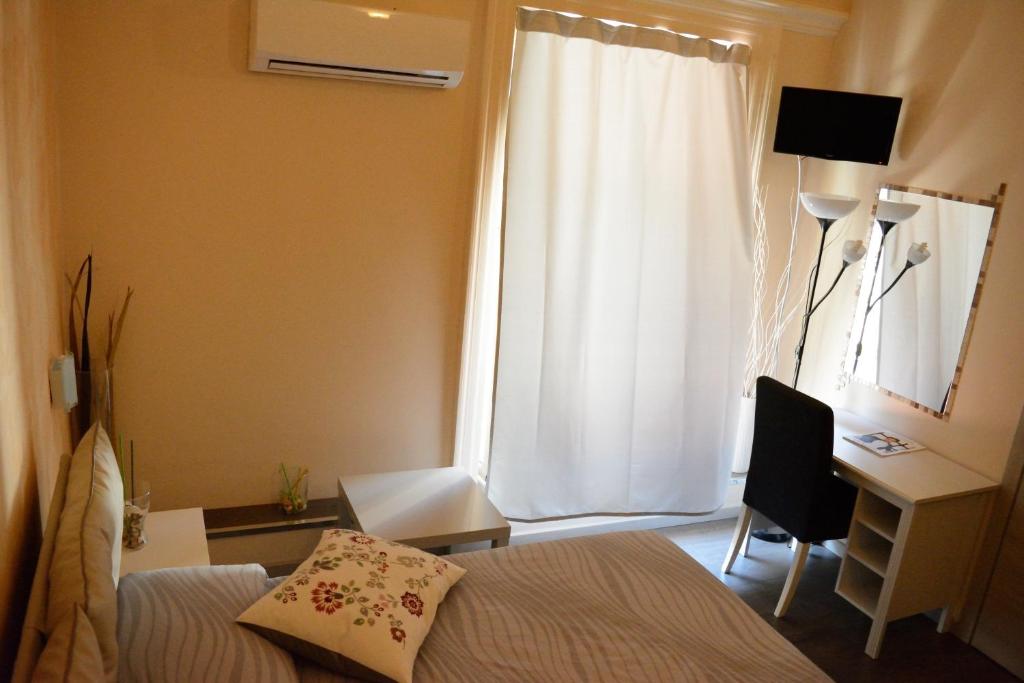 1 dormitorio con cama, escritorio y ventana en Catania Etnea Bed and breakfast, en Catania