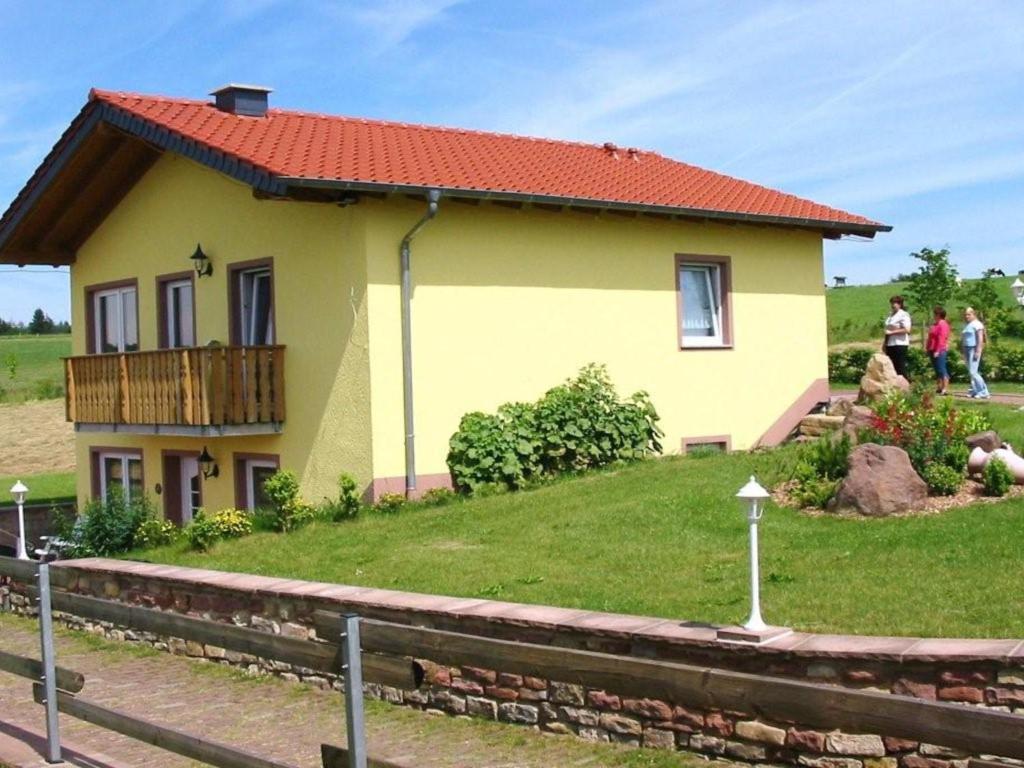 a small yellow house with a red roof at Apartment with balcony in the Gransdorf Eifel in Gransdorf