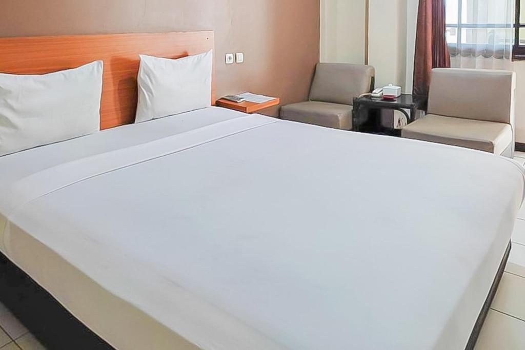 Ένα ή περισσότερα κρεβάτια σε δωμάτιο στο Fajar Indah Hotel Mitra RedDoorz