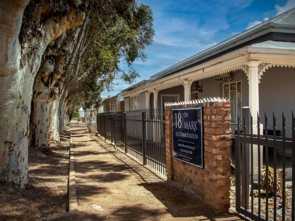 a sign on a fence in front of a house at 18 on Mark in Willowmore
