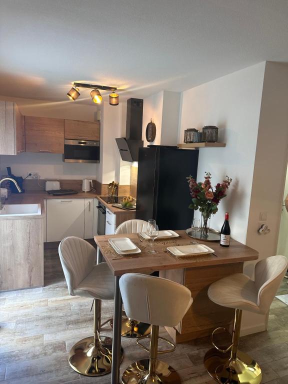 une cuisine avec une table en bois et des chaises ainsi qu'une salle à manger dans l'établissement Domaine privé OnLy Roc, à Roquebrune-sur Argens